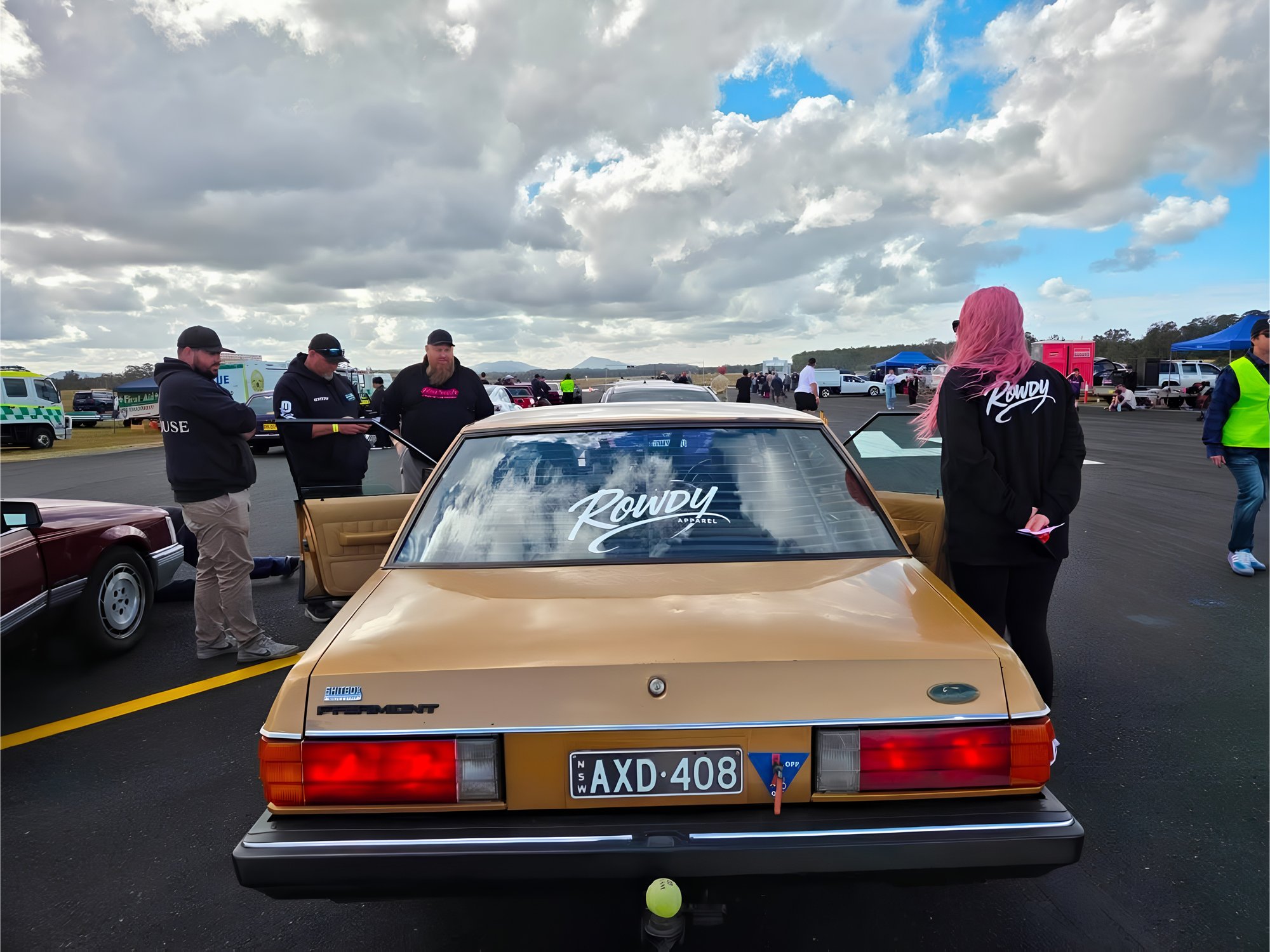 The Rowdy crew and their gold Ford Fairmont in the staging lanes at a drag strip